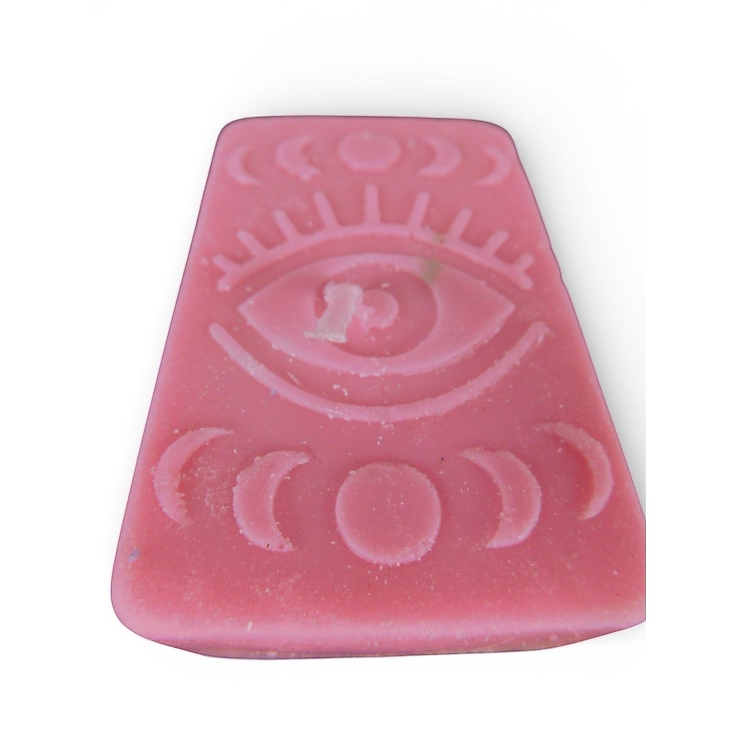 The Witches' Quest handmade pink rectangular wax candle with embossed mystical eye and moon phase celestial design.