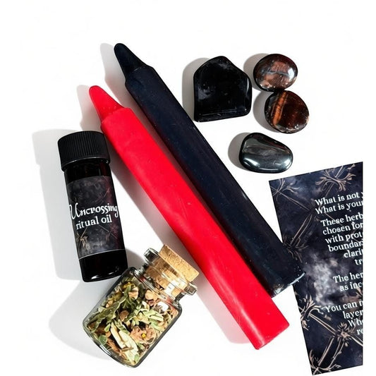 The Witches' Quest Return to Sender ritual kit with red and black candles, uncrossing oil, herb blend, and crystals.