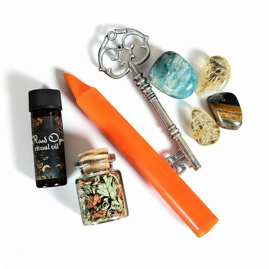 The Witches' Quest Unlocked Spell Kit for Road Opening with orange candle, skeleton key, ritual oil, herbs, and crystals.