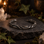 Norse Viking torque silver tone cuff metal bracelet on a dark stone surface