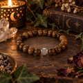 Natural wood bead faith stretch bracelet with a silver cross accent on a wooden surface