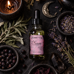 Hecate Sacred Ritual Oil bottle surrounded by dried herbs, berries, a candle, and a crescent moon charm