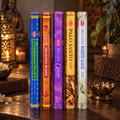 Five hexagonal boxes of HEM ceremonial incense sticks standing upright on a wooden table