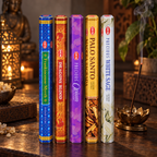 Five hexagonal boxes of HEM ceremonial incense sticks standing upright on a wooden table