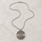 Celtic Tree of Life pendant necklace in alloy on a textured stone background