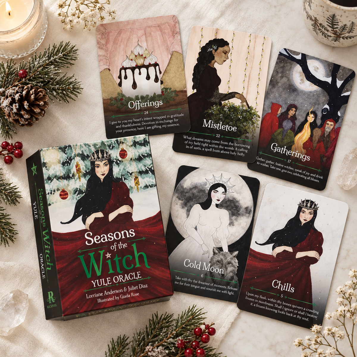 Seasons of the Witch Yule Oracle deck box and cards featuring festive illustrations on a table with holiday decor