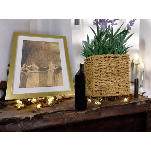 Black Obsidian Crystal Tower Point on a rustic wooden shelf with a framed print and a woven basket of lavender