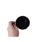 Hand holding an empty Protect Your Energy mug with a black interior and handle