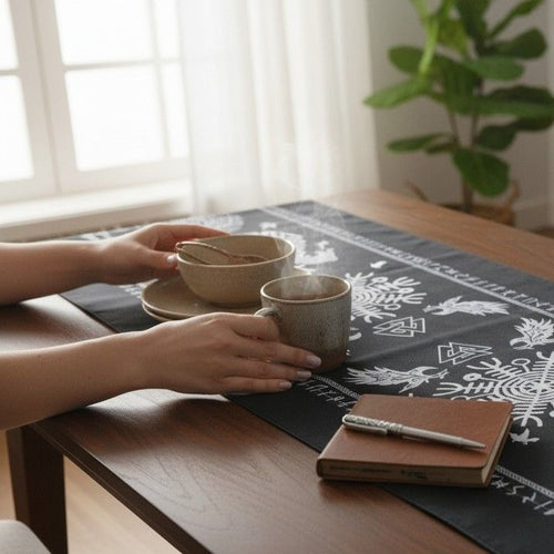 Black Viking Tree of Life table runner with raven and Helm of Awe Nordic patterns on a wooden dining table