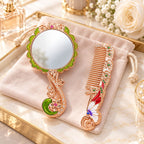 Butterfly and floral hand mirror and comb set in rose gold tone with enamel accents on a velvet pouch