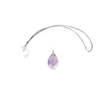 The Witches' Quest amethyst teardrop pendant with copper wire wrapped tree of life design on a black cord necklace.