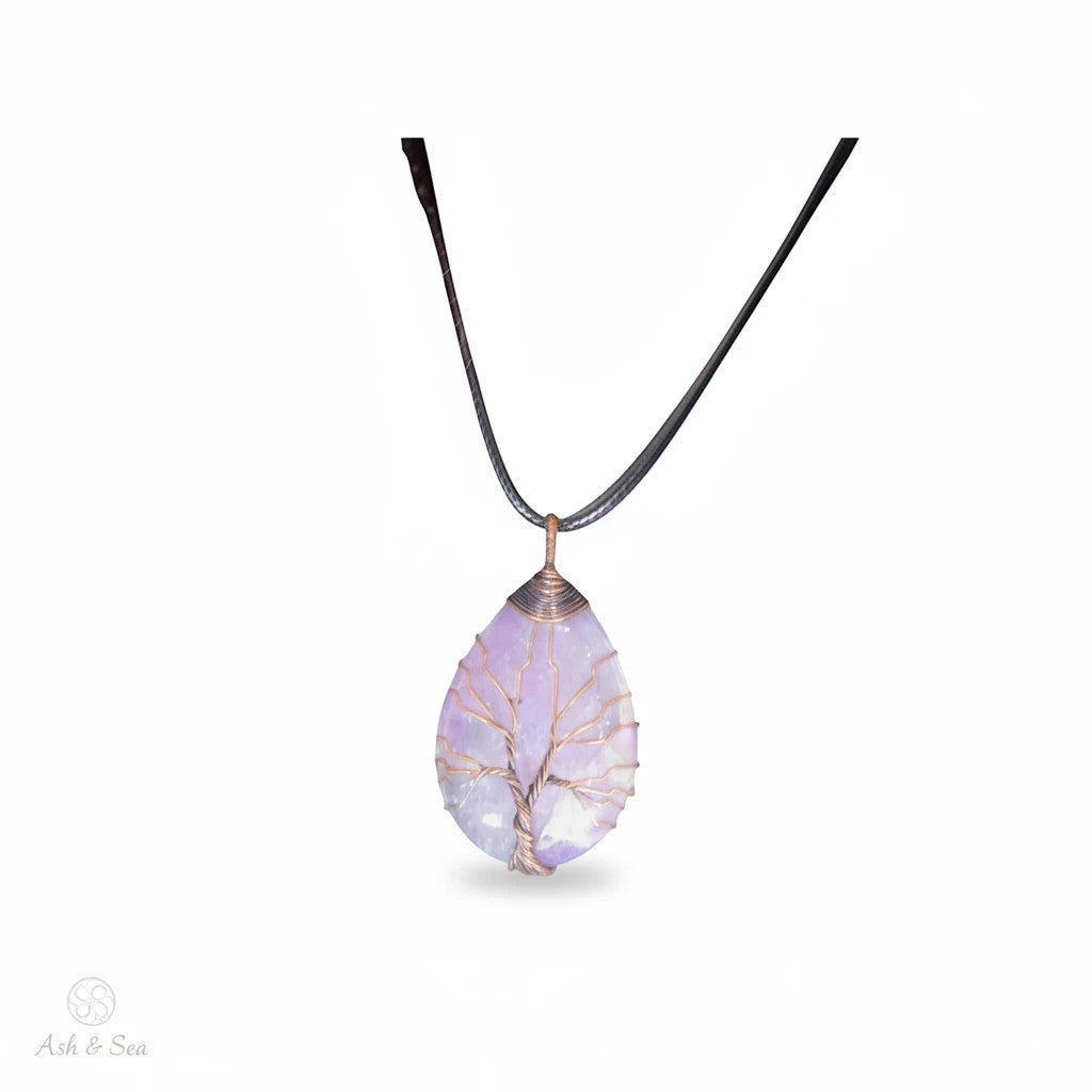 The Witches' Quest amethyst teardrop pendant with a copper wire wrapped tree of life design on a black cord necklace.