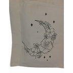 The Witches' Quest beige canvas tote bag featuring a black line art crescent moon with floral and star details.