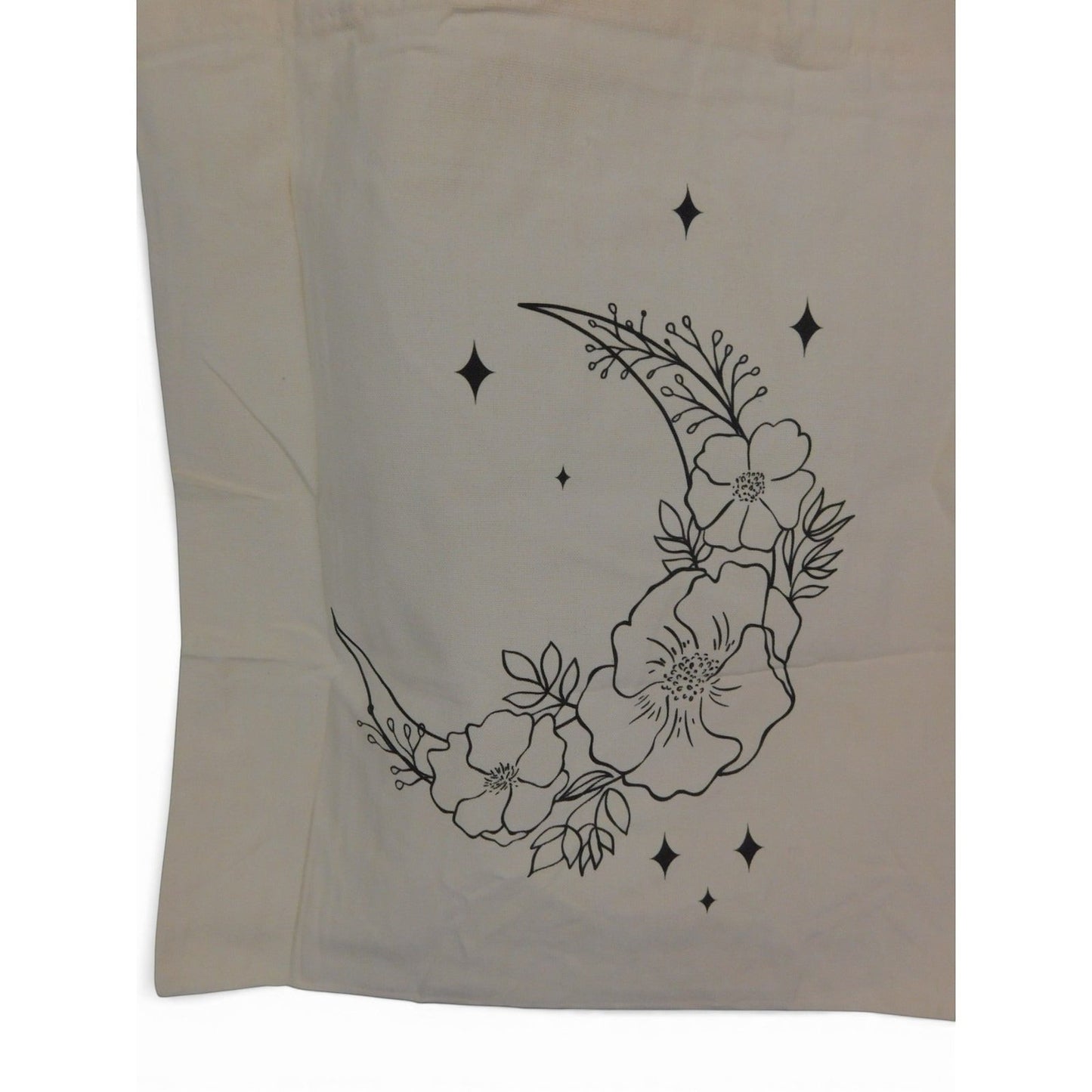 The Witches' Quest beige canvas tote bag featuring a black line art crescent moon with floral and star details.