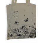 The Witches' Quest beige canvas tote bag featuring black line-art of mushrooms, butterflies, and a crescent moon.
