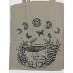 The Witches' Quest beige canvas tote bag featuring black line-art of mushrooms, butterflies, and celestial moon phases.