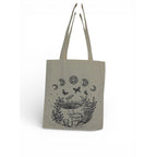 The Witches' Quest beige canvas tote bag featuring black line-art illustrations of mushrooms, butterflies, and moons.