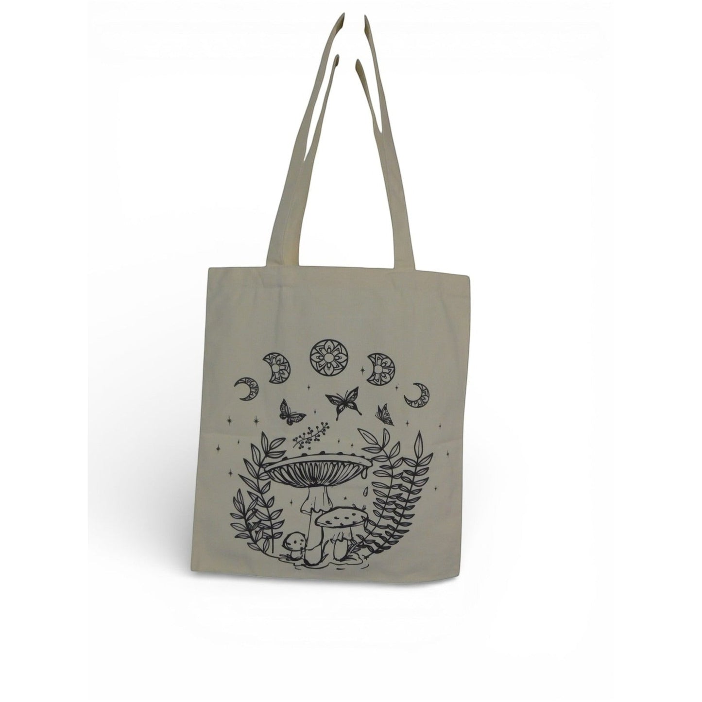 The Witches' Quest beige canvas tote bag featuring black line-art illustrations of mushrooms, butterflies, and moons.