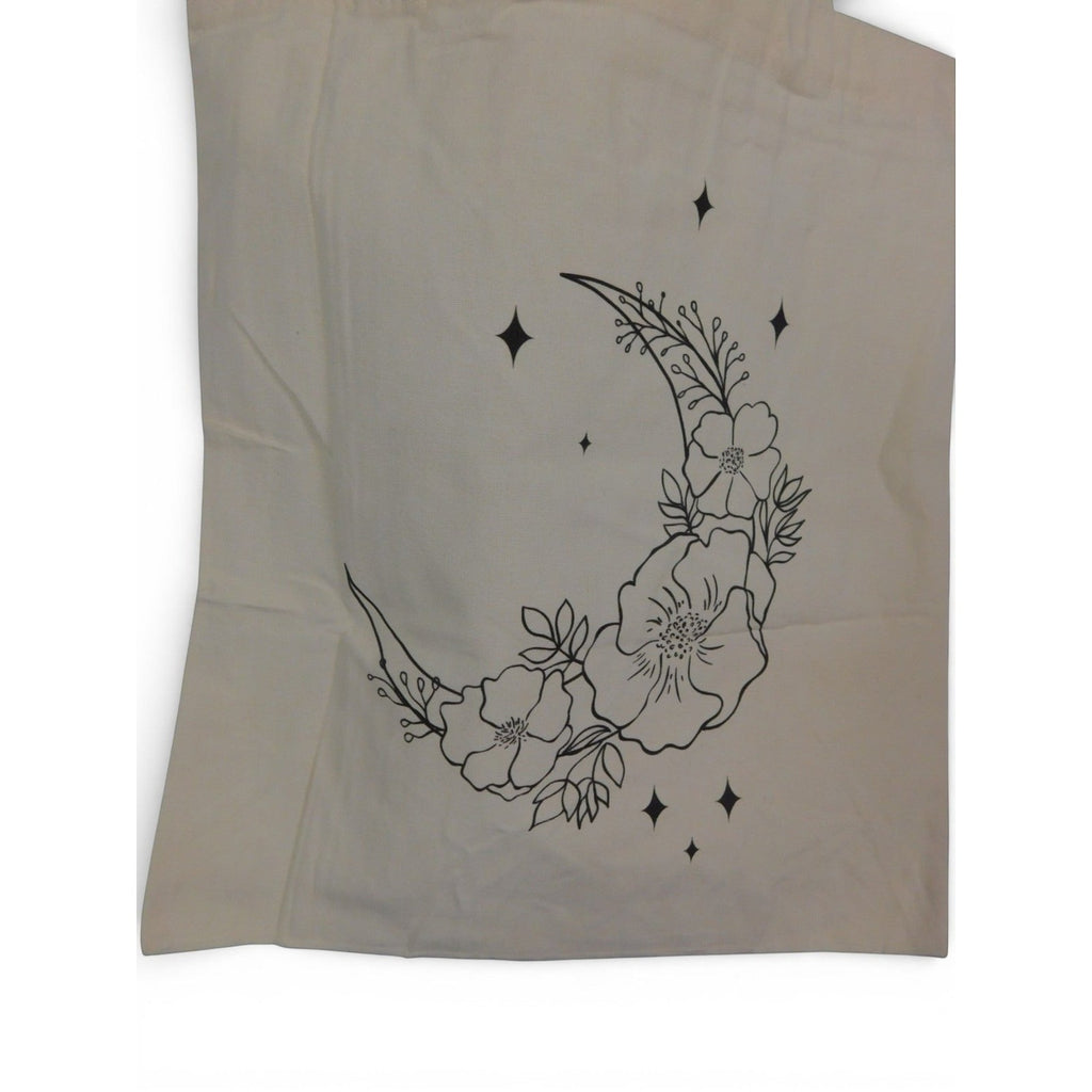 The Witches' Quest beige canvas tote bag featuring a black line art crescent moon, floral, and star print.