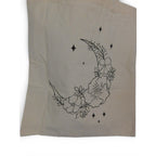 The Witches' Quest beige canvas tote bag featuring a black line art crescent moon, floral, and star print.