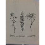 The Witches' Quest large beige canvas tote bag with black floral line art and Grow positive thoughts text