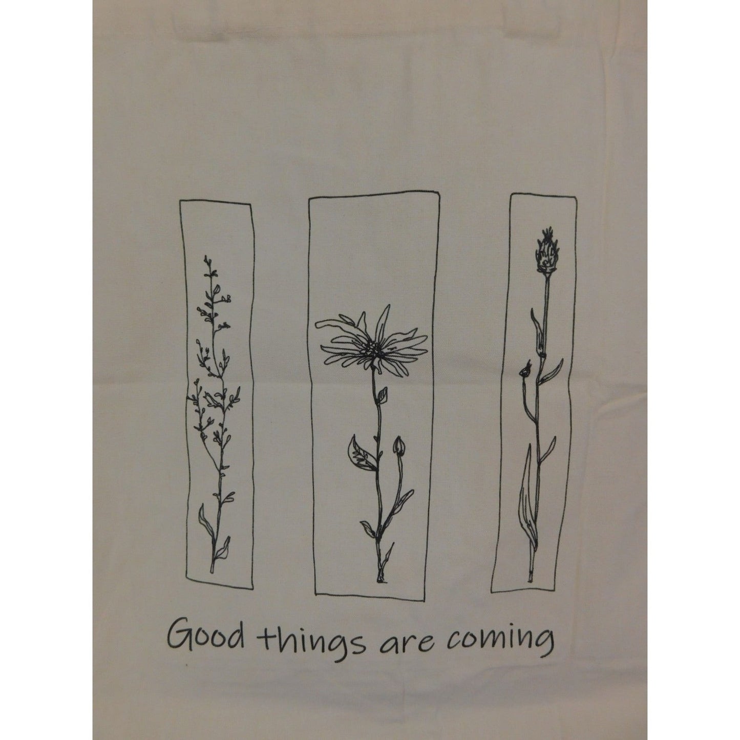 The Witches' Quest beige canvas tote bag featuring black floral line art panels and Good things are coming text