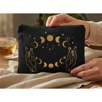 The Witches' Quest black canvas zipper pouch with gold celestial moon phase and hand print design.