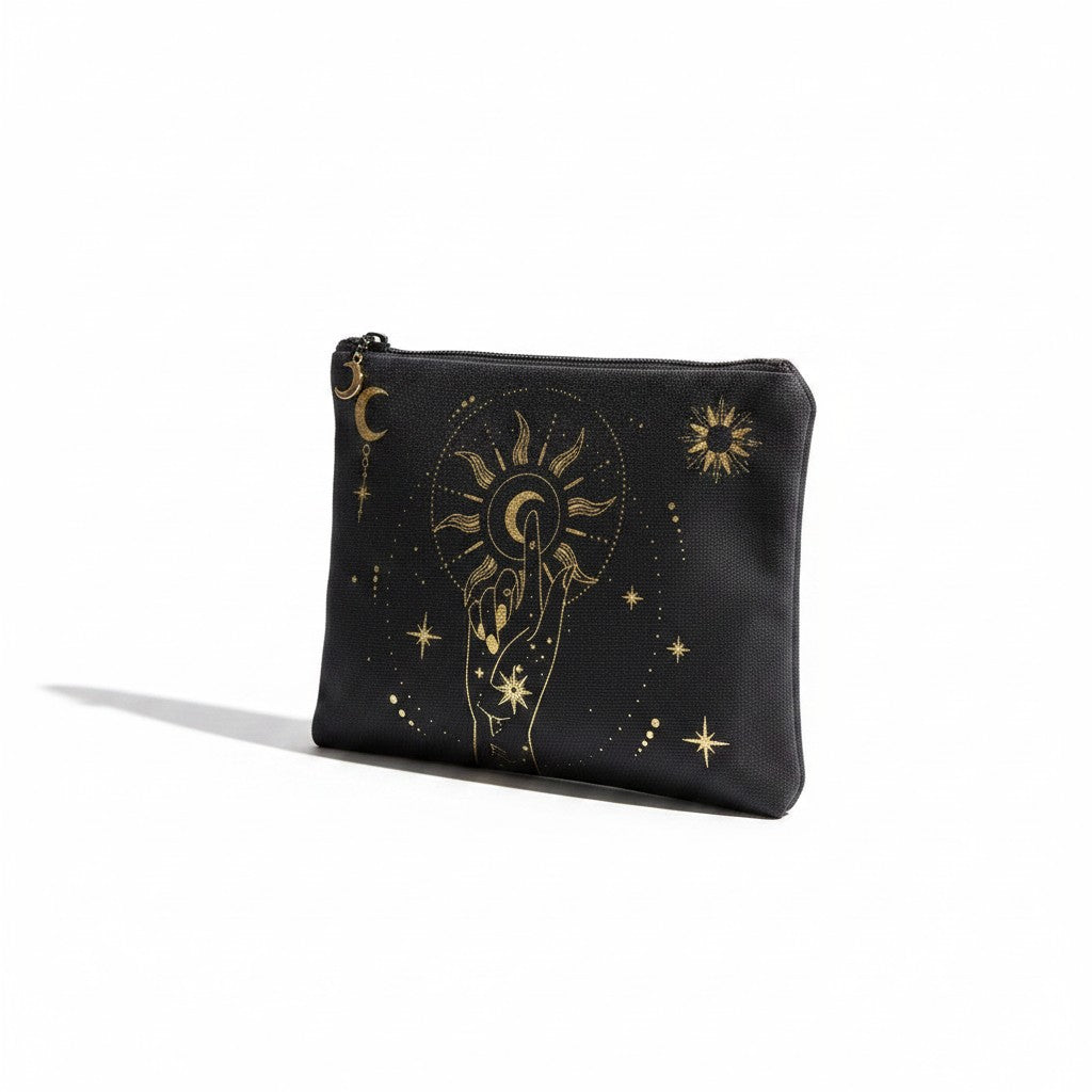 The Witches' Quest black canvas clutch featuring a gold celestial hand, moon, and sun print with a top zipper closure.