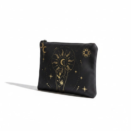The Witches' Quest black canvas clutch featuring a gold celestial hand, moon, and sun print with a top zipper closure.