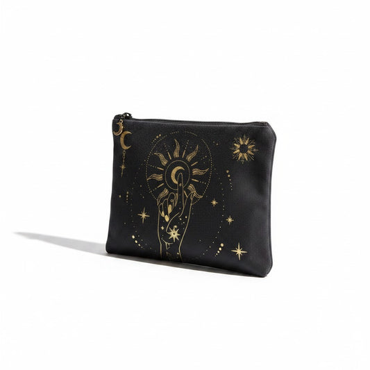 The Witches' Quest black canvas clutch featuring a gold celestial hand, moon, and sun print with a top zipper closure.