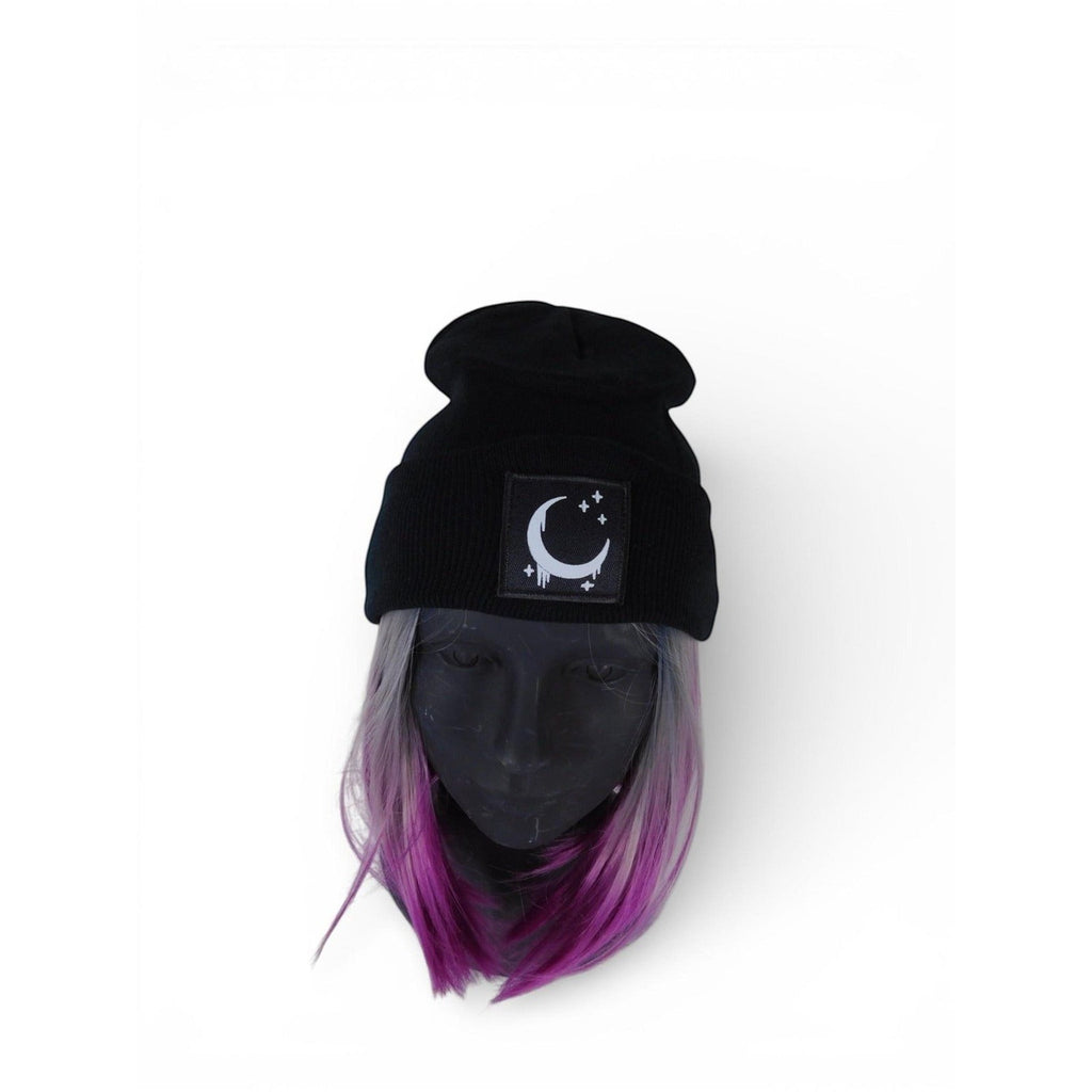 The Witches' Quest black ribbed knit beanie with a crescent moon and stars patch on a mannequin head