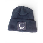 The Witches' Quest black ribbed knit beanie with a square crescent moon and stars patch on the cuffed front.