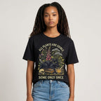 The Witches' Quest black cotton t-shirt featuring a botanical cat graphic with the text All Plants Are Edible