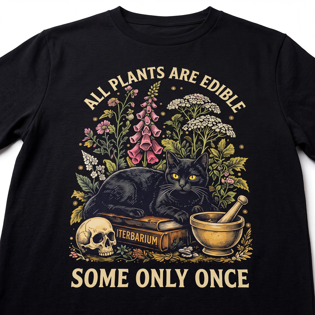 The Witches' Quest black cotton t-shirt featuring a graphic of a black cat, skull, and plants with text.