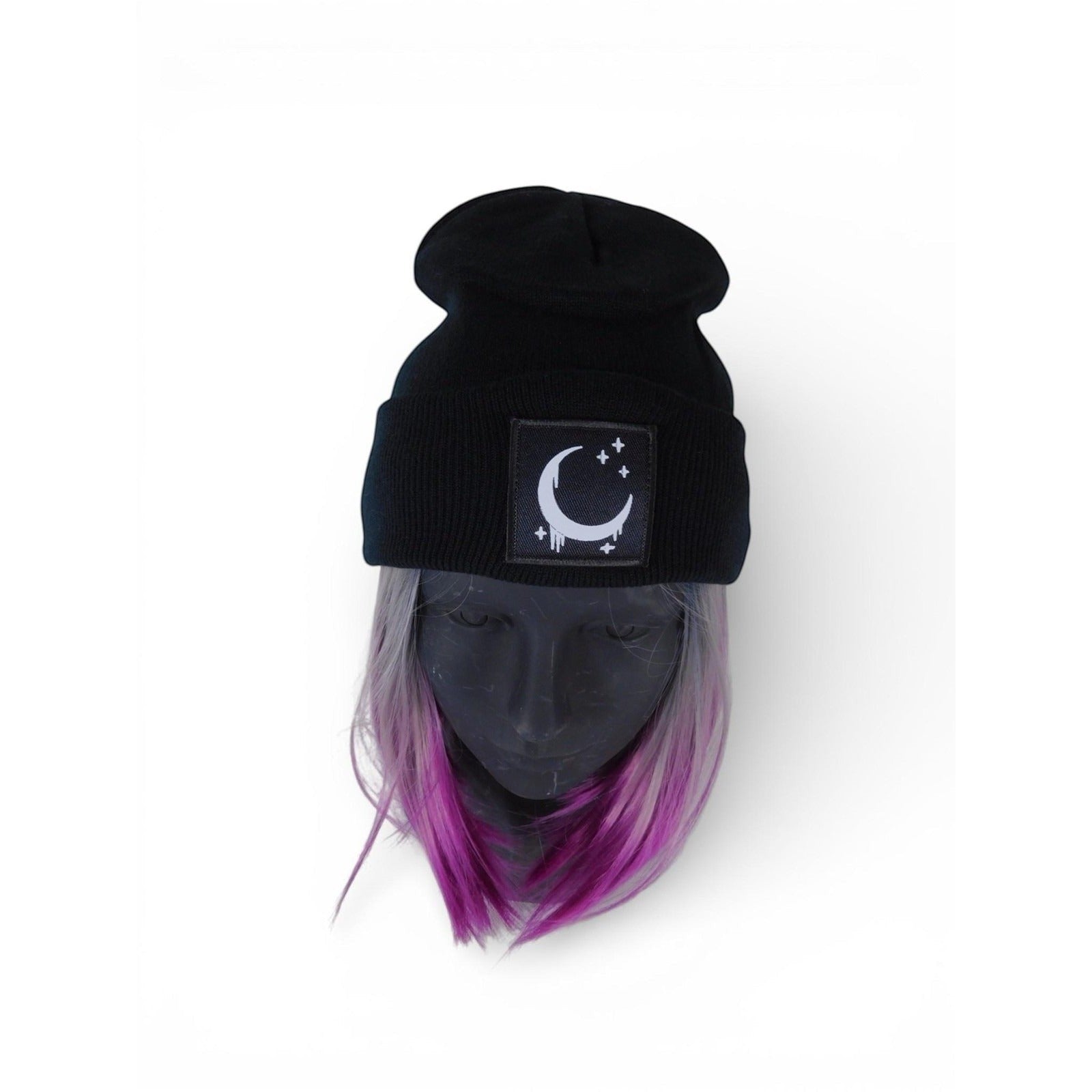 The Witches' Quest black ribbed knit beanie with a crescent moon and stars patch and satin lining on a mannequin.