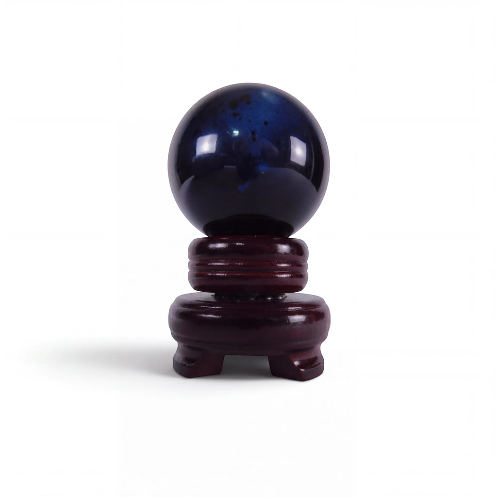 The Witches' Quest polished black obsidian sphere for scrying and meditation, displayed on a dark wooden stand.