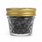 The Witches' Quest black ritual salt in a small glass jar with a gold twist-off lid for protection and cleansing