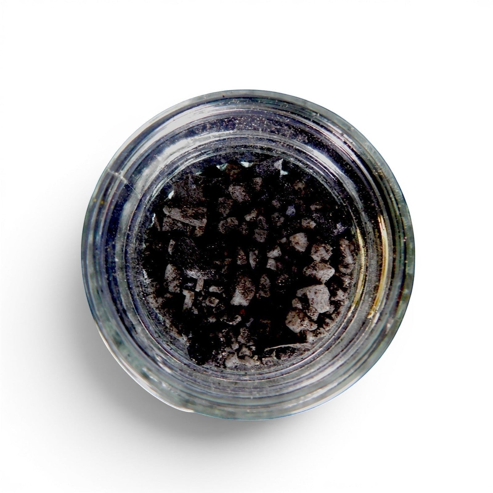 The Witches' Quest black salt in a glass jar, featuring coarse sea salt mixed with birch and mahogany ash for rituals.