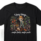 The Witches' Quest black cotton t-shirt featuring a skeleton gardener graphic with the text I bury things maybe plants