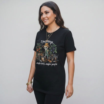 The Witches' Quest black cotton t-shirt featuring a skeleton gardener graphic with the text I bury things