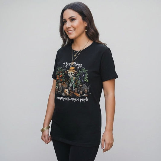 The Witches' Quest black cotton t-shirt featuring a skeleton gardener graphic with the text I bury things