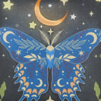 The Witches' Quest travel cosmetic bag featuring a blue butterfly, orange crescent moon, and yellow stars on black.