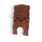 The Witches' Quest handcrafted wooden book stand featuring intricate floral carvings and a central triquetra symbol.