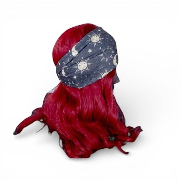 The Witches' Quest celestial moon and star print stretchy headband on a mannequin with vibrant red hair