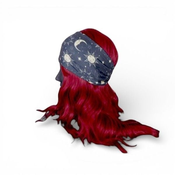 The Witches' Quest celestial moon and star print stretchy fabric headband on a mannequin with vibrant red hair.