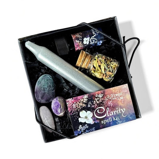 The Witches' Quest Forest and Fae Clarity Spell Kit featuring a ritual candle, botanical herbs, oil, and crystals.