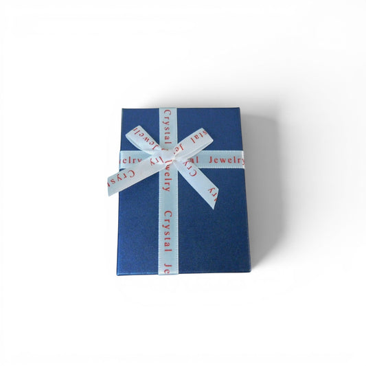 The Witches' Quest blue gift box with white ribbon containing a 14-piece chakra hexagonal crystal gemstone set.