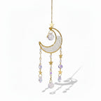 The Witches' Quest crescent moon sun catcher with gold stars, clear crystal beads, and teardrop prisms on a gold chain.