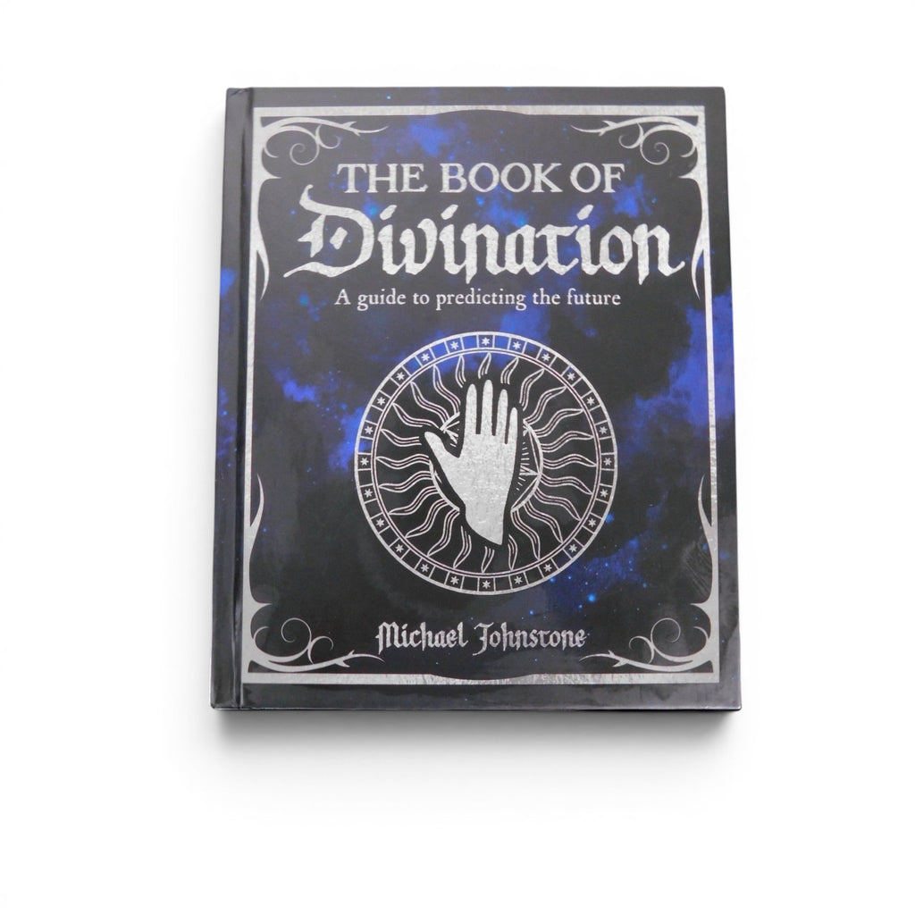 The Witches' Quest hardcover Book of Divination featuring a celestial blue and black cover with silver palmistry art.