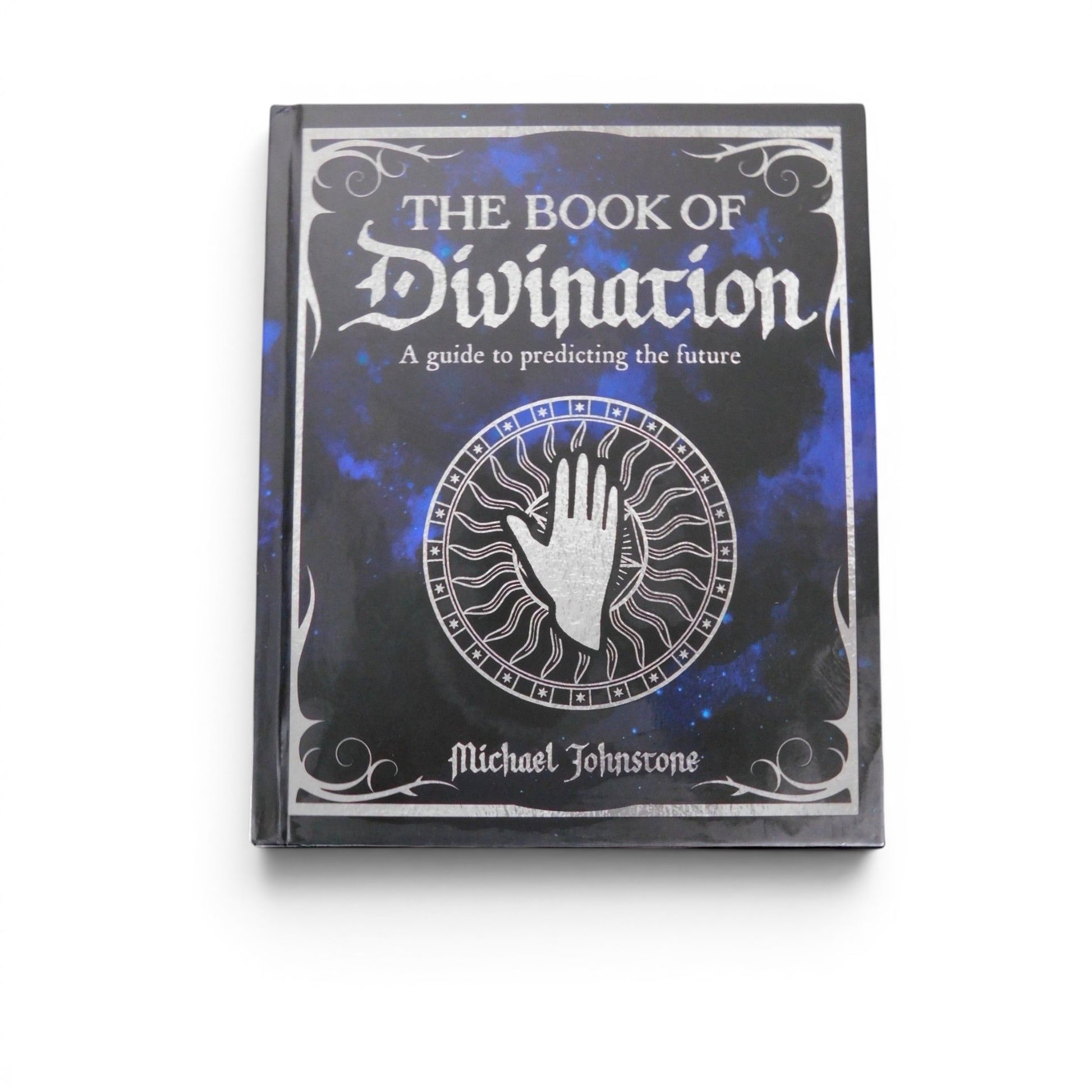 The Witches' Quest hardcover Book of Divination featuring a celestial blue and black cover with silver palmistry art.